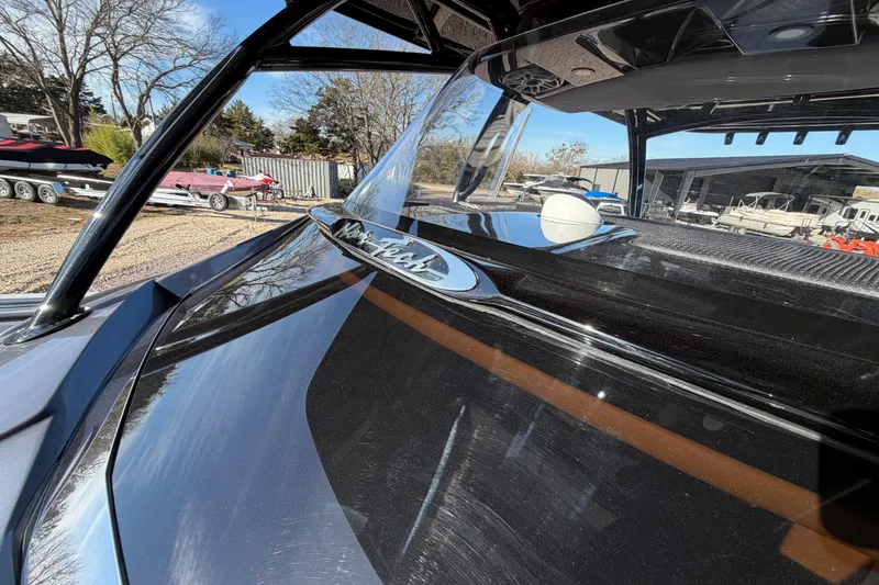 Slide: The Image of 2022 Nor-Tech 390 Sport Center Console boat, sleek black design, outdoor display. - 15