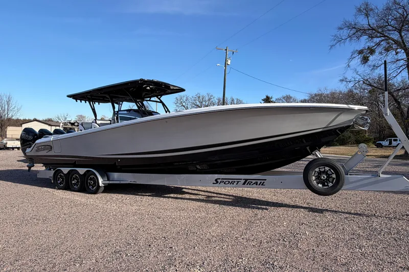 Slide: The Image of 2022 Nor-Tech 390 Sport Center Console boat on trailer, parked outdoors. - 2