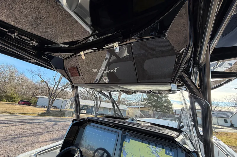 Slide: The Image of 2022 Nor-Tech 390 Sport Center Console dashboard with navigation display and overhead storage. - 29