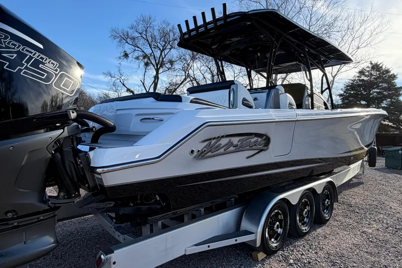 Slide: The Image of 2022 Nor-Tech 390 Sport Center Console boat on trailer, featuring powerful outboard engine. - 4
