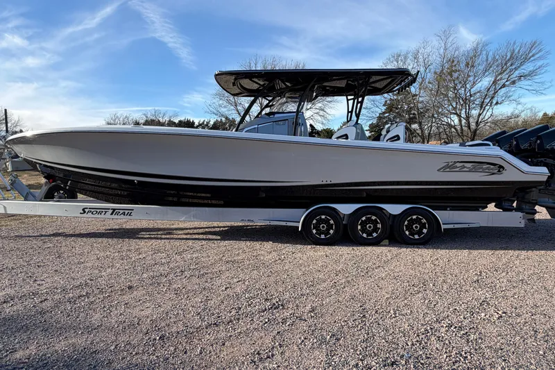 Slide: The Image of 2022 Nor-Tech 390 Sport Center Console boat on trailer, side view under clear sky. - 8