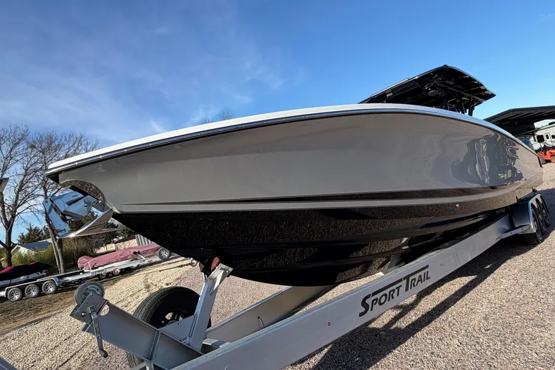 Slide: The Image of 2022 Nor-Tech 390 Sport Center Console boat on trailer, side view under clear blue sky. - 9