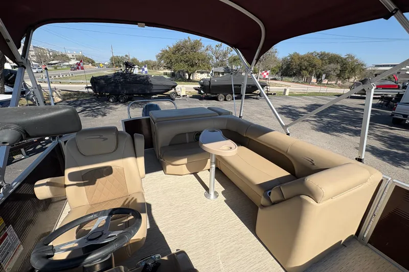 Slide: The Image of 2016 Bennington 21 SLX pontoon boat interior with tan seating and steering wheel. - 10