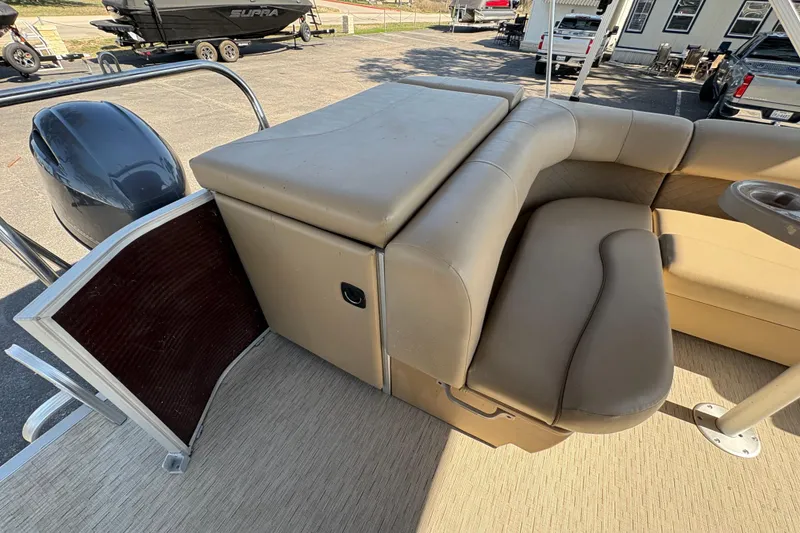 Slide: The Image of 2016 Bennington 21 SLX pontoon boat interior with tan seating and storage area. - 11