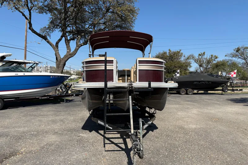 Slide: The Image of 2016 Bennington 21 SLX pontoon boat on trailer, parked outdoors. - 2