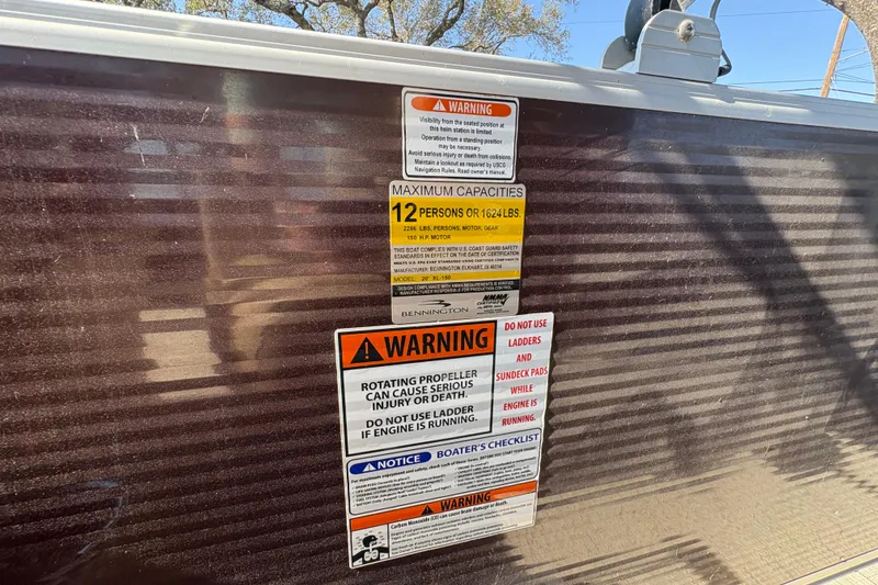 Slide: The Image of 2016 Bennington 21 SLX boat warning labels detailing capacity and safety instructions. - 21