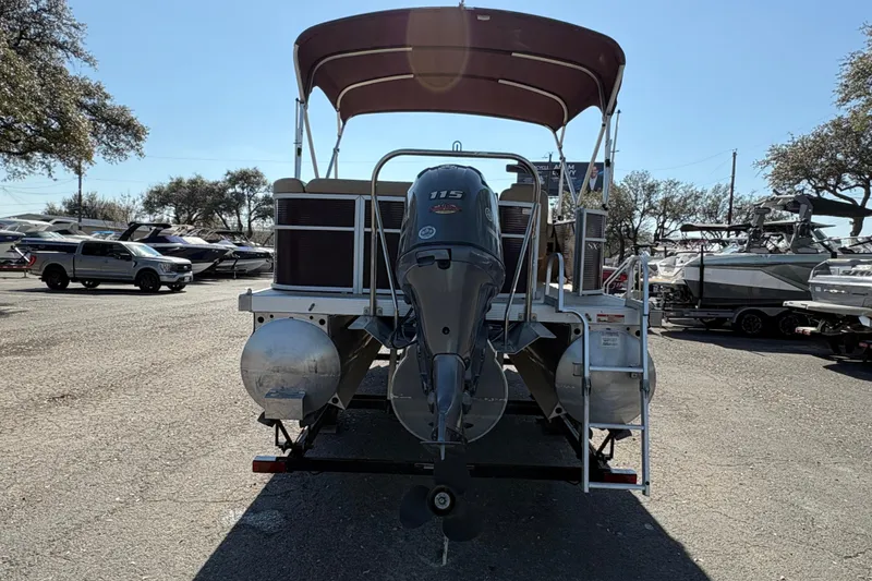 Slide: The Image of 2016 Bennington 21 SLX pontoon boat with outboard motor, parked in a marina. - 6