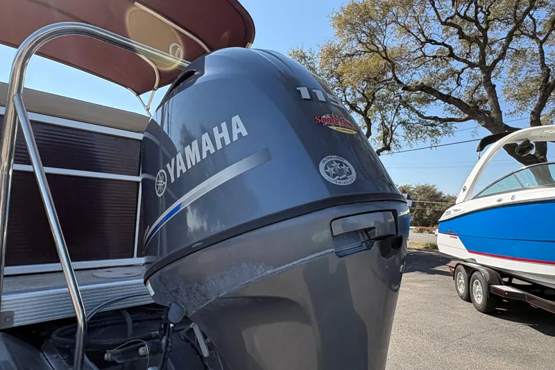 Slide: The Image of 2016 Bennington 21 SLX with Yamaha outboard motor, parked near a blue and white boat. - 7