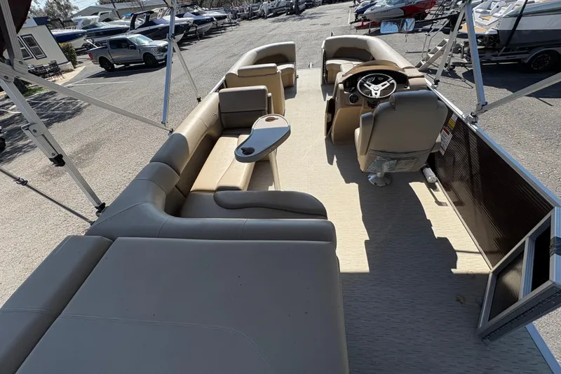 Slide: The Image of 2016 Bennington 21 SLX pontoon boat interior with beige seating and steering console. - 9