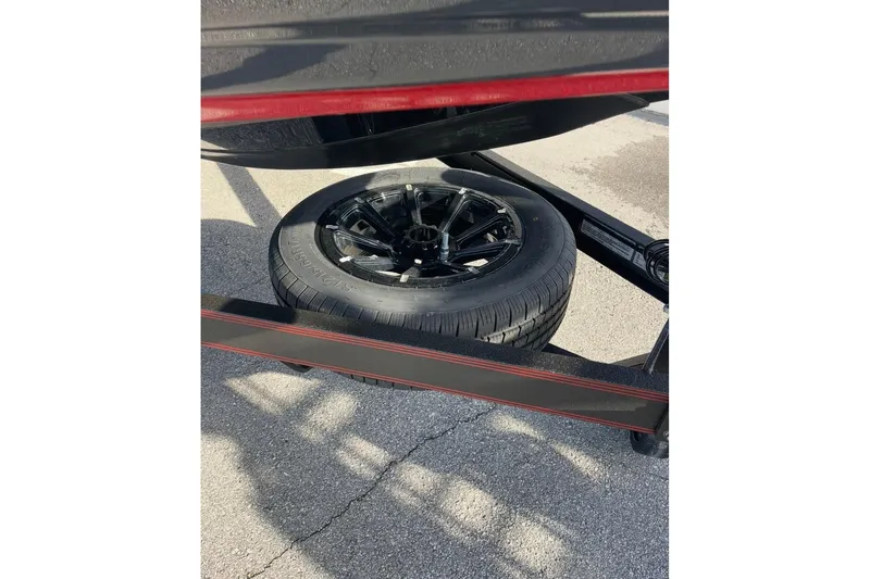 Slide: The Image of 2026 Skeeter FXR20 FLEX trailer with a spare tire on pavement. - 24