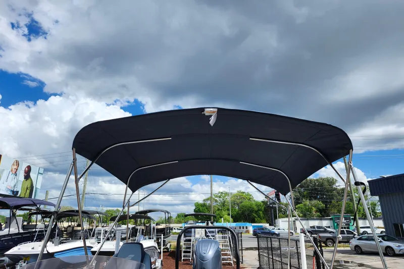 Slide: The Image of 2026 Starcraft SVX 211 OB boat with canopy under a partly cloudy sky. - 13