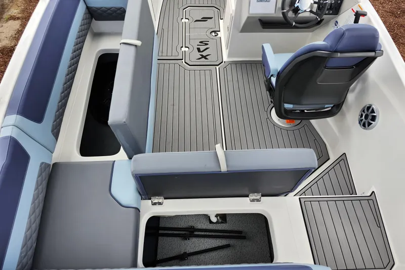 Slide: The Image of 2026 Starcraft SVX 211 OB boat interior with gray flooring and blue seating. - 23