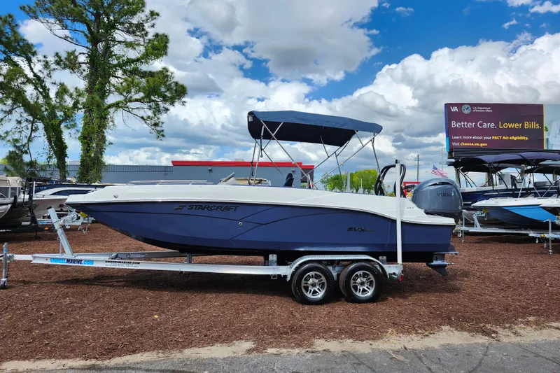 Slide: The Image of 2026 Starcraft SVX 211 OB boat on trailer, displayed outdoors under a cloudy sky. - 3