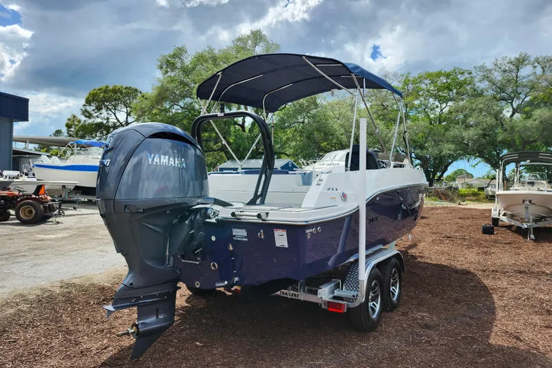 Slide: The Image of 2026 Starcraft SVX 211 OB boat with Yamaha outboard motor, parked outdoors under cloudy sky. - 7