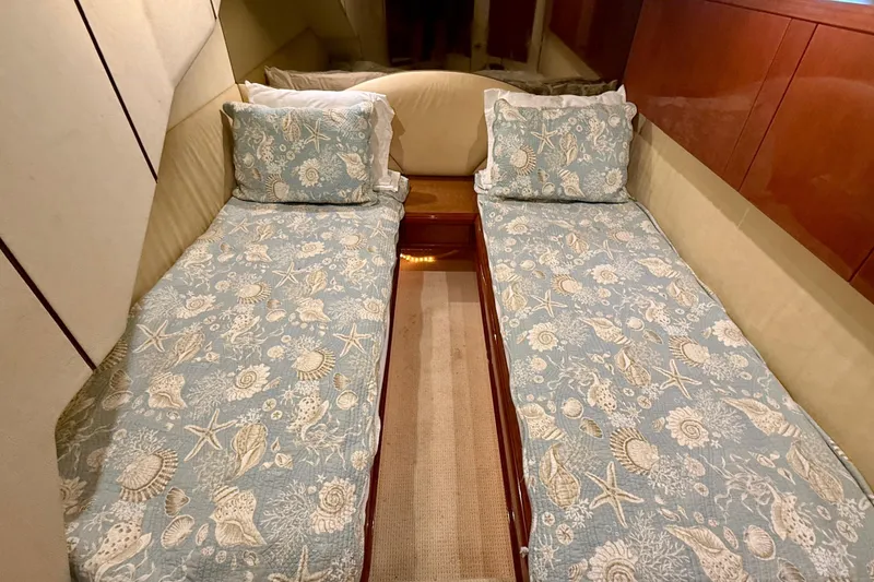 Slide: The Image of Twin beds with seashell-patterned bedding in a 2000 Fairline Squadron 55 yacht cabin. - 18