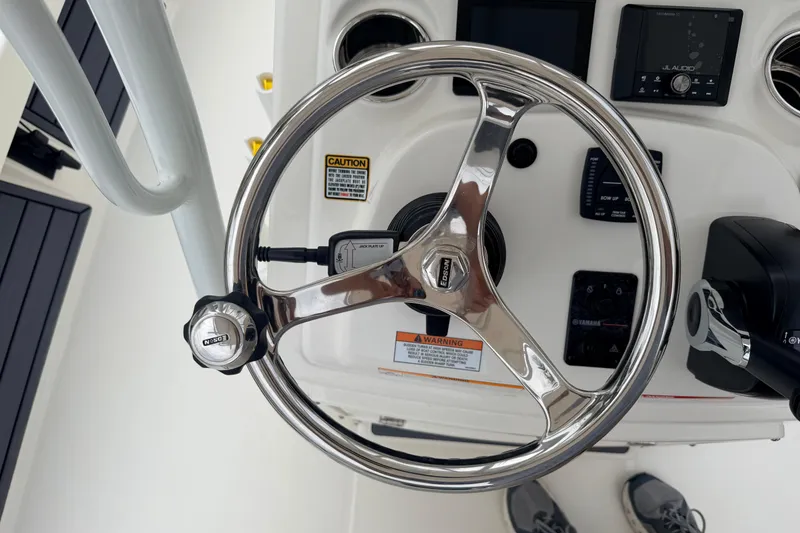 Slide: The Image of Steering wheel of 2026 Pathfinder 2200 TRS boat with control panel and warning labels. - 14
