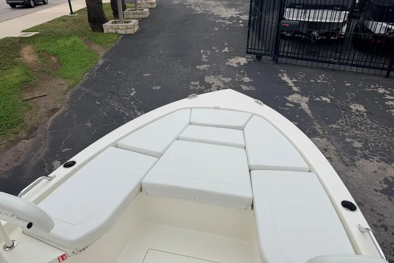 Slide: The Image of 2026 Pathfinder 2200 TRS boat with white cushioned seating on a paved surface. - 34