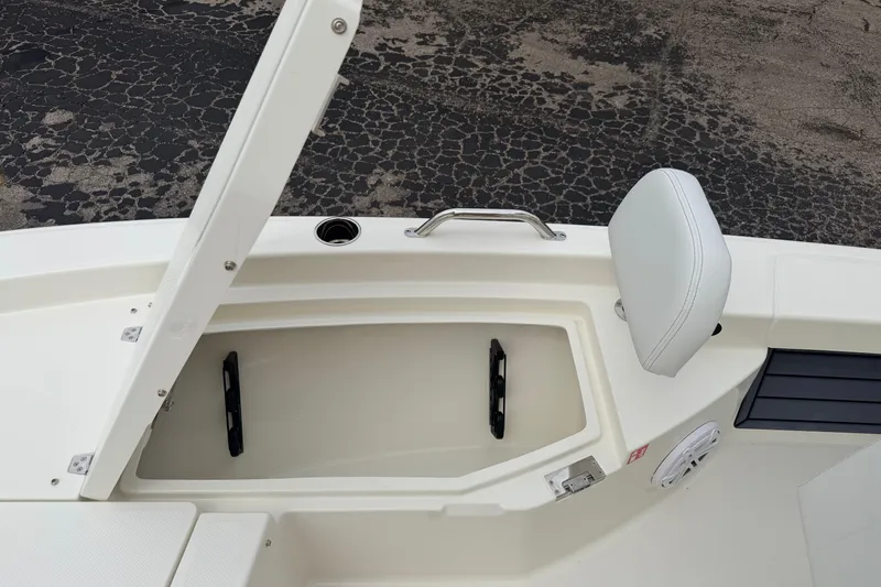 Slide: The Image of 2026 Pathfinder 2200 TRS boat storage compartment with open lid and cushioned seat. - 38