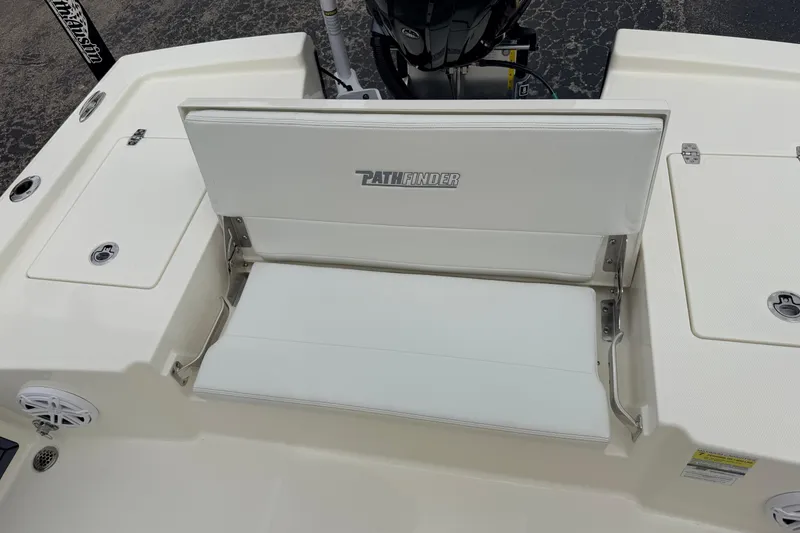Slide: The Image of 2026 Pathfinder 2200 TRS boat with white seating and storage compartments. - 49