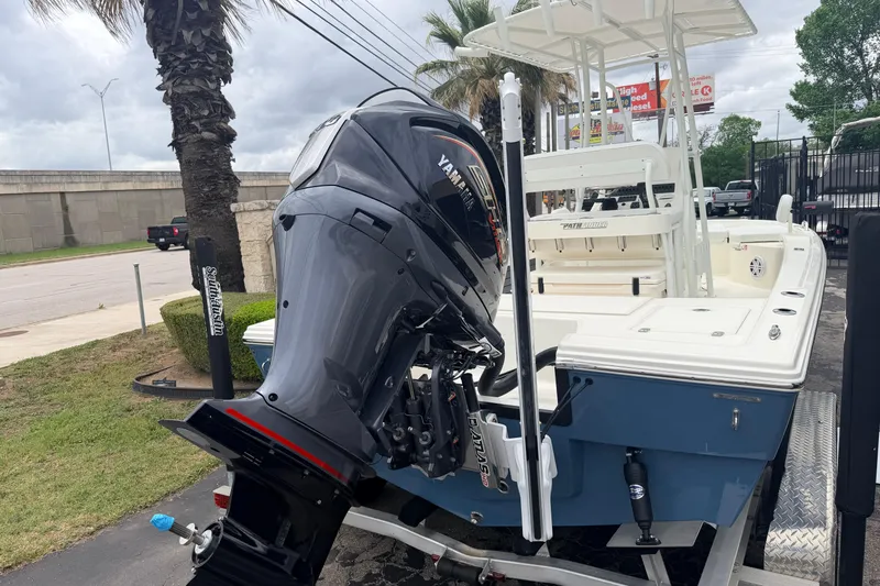 Slide: The Image of 2026 Pathfinder 2200 TRS boat with Yamaha outboard motor, parked near palm trees. - 6