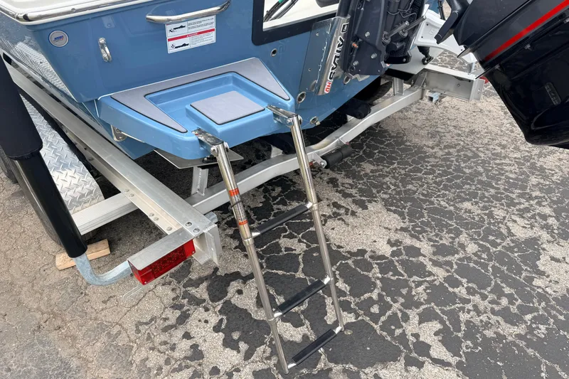 Slide: The Image of 2026 Pathfinder 2200 TRS boat with ladder on trailer, showcasing rear design and motor. - 7