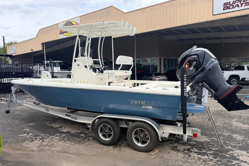 Slide: The Image of 2026 Pathfinder 2200 TRS boat on trailer, displayed outside a dealership. - 8