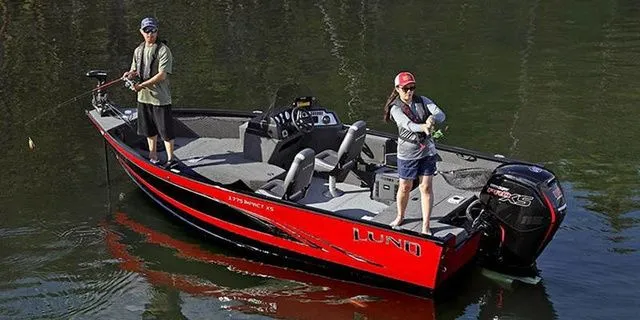 Slide: The Image of Two people fishing on a 2026 Lund 1775 Impact XS boat. - 2