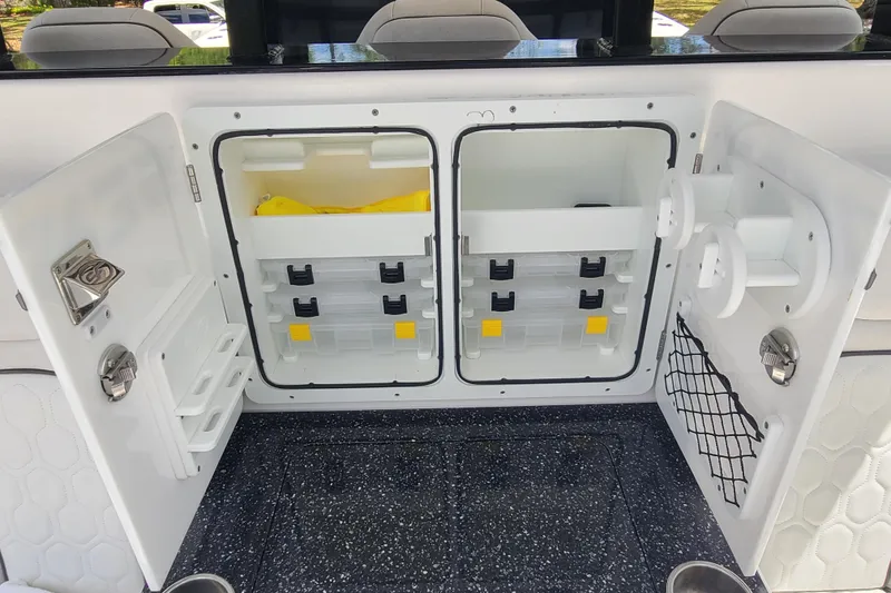 Slide: The Image of 2022 Sea Fox 368 Commander storage compartments with organized tackle boxes and accessories. - 14