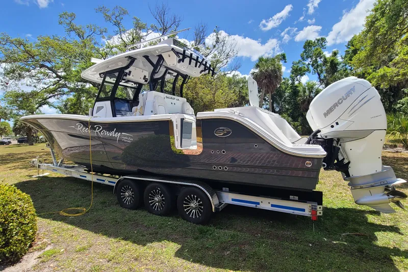 Slide: The Image of 2022 Sea Fox 368 Commander boat on trailer with Mercury outboard engine, parked outdoors. - 2