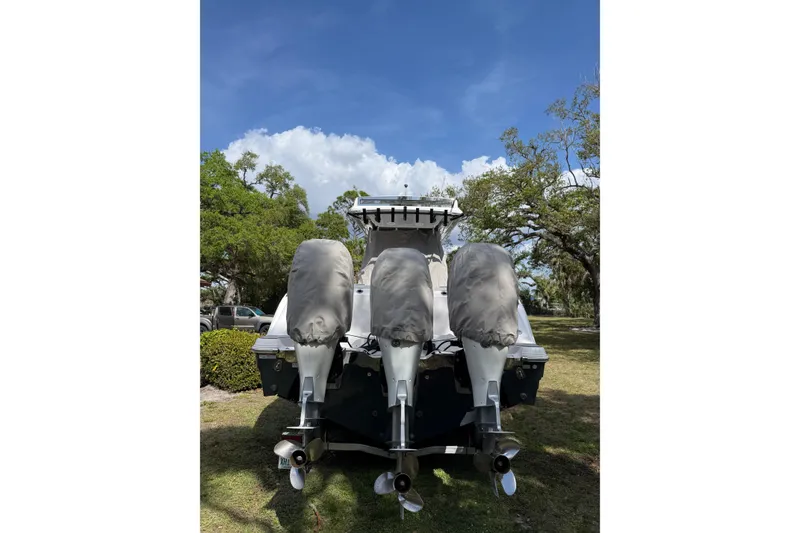 Slide: The Image of 2022 Sea Fox 368 Commander boat with triple outboard engines, parked on grass. - 48