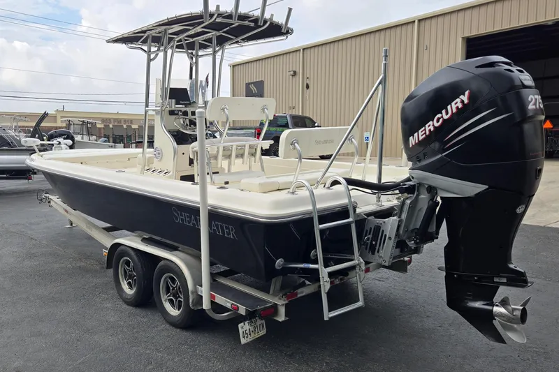Slide: The Image of 2006 ShearWater 2400Z boat with Mercury engine on trailer, parked outside a warehouse. - 5