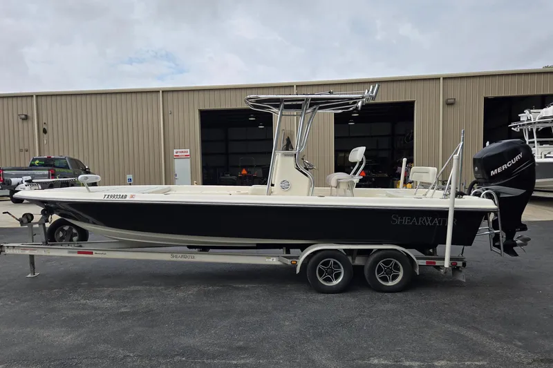 Slide: The Image of 2006 ShearWater 2400Z boat on trailer, parked outside a warehouse. - 6