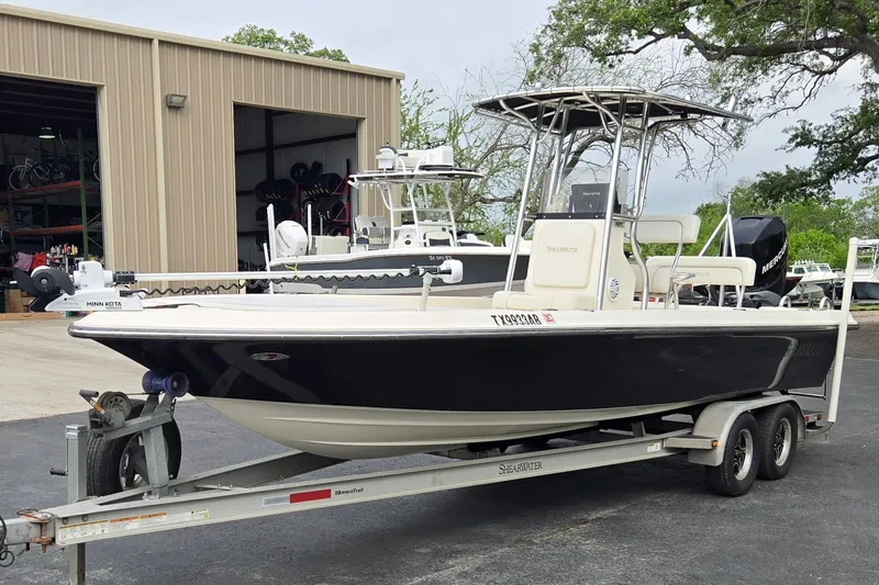 Slide: The Image of 2006 ShearWater 2400Z boat on trailer, parked outside a storage facility. - 7