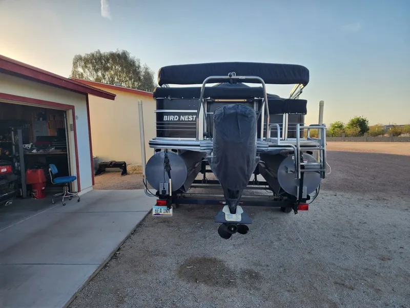 Slide: The Image of 2015 Lowe SS210 pontoon boat parked in backyard. - 2