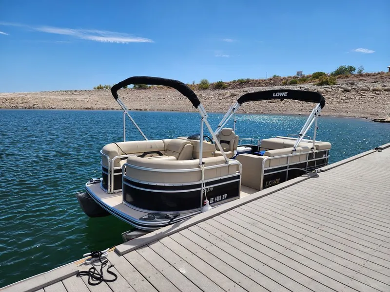 Slide: The Image of 2015 Lowe SS210 pontoon boat docked on calm water. - 6
