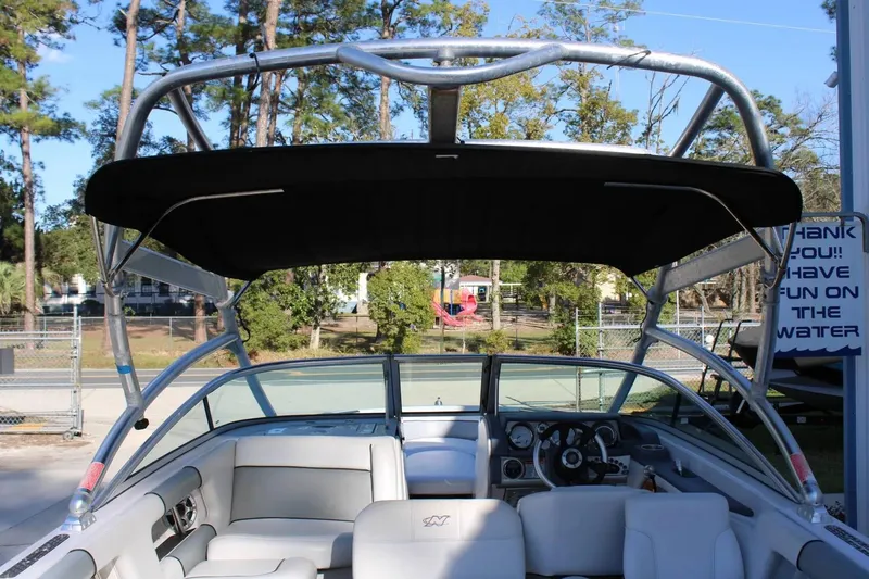 Slide: The Image of 2007 Nautique Super Air Nautique 230 boat interior with canopy, steering wheel, and seating. - 3