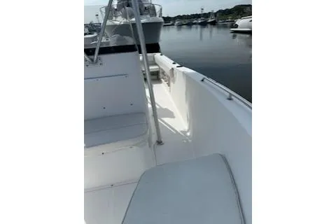 Slide: The Image of 2006 Sea Hunt Triton 220 boat interior, featuring white seating and dockside view. - 11