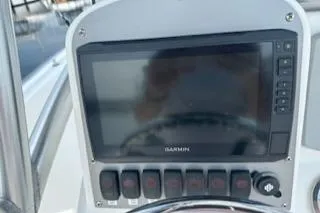 Slide: The Image of 2006 Sea Hunt Triton 220 dashboard with Garmin navigation system and control switches. - 12