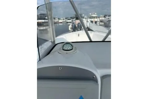 Slide: The Image of 2006 Sea Hunt Triton 220 boat dashboard with compass, docked in marina. - 13