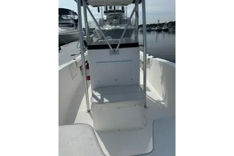 Slide: The Image of 2006 Sea Hunt Triton 220 boat interior with console, docked on calm water. - 20