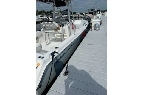 Slide: The Image of 2006 Sea Hunt Triton 220 boat docked at a marina under a clear sky. - 21