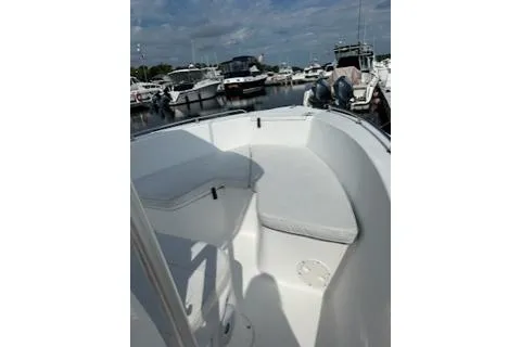 Slide: The Image of 2006 Sea Hunt Triton 220 boat interior at marina, featuring seating and clear skies. - 24