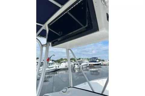 Slide: The Image of 2006 Sea Hunt Triton 220 boat with open storage compartment, docked at marina. - 25