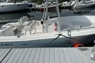 Slide: The Image of 2006 Sea Hunt Triton 220 boat docked at a marina, featuring white seating and safety equipment. - 26