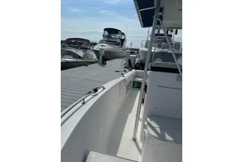 Slide: The Image of 2006 Sea Hunt Triton 220 boat docked at marina with other vessels. - 4