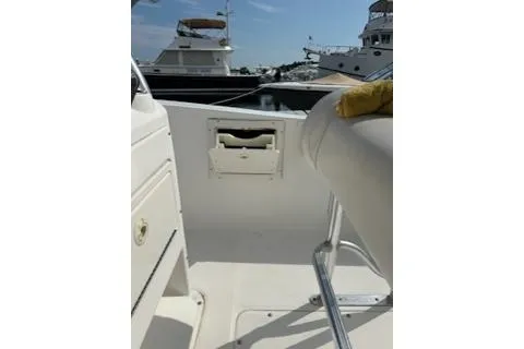 Slide: The Image of 2006 Sea Hunt Triton 220 boat interior with seating and storage, docked at a marina. - 8