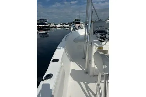 Slide: The Image of 2006 Sea Hunt Triton 220 boat docked in a marina under a partly cloudy sky. - 9