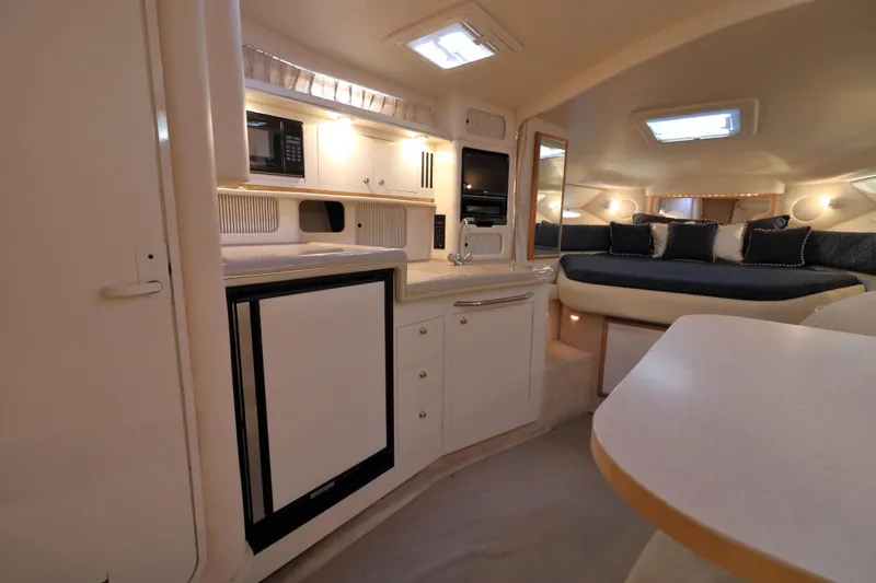Slide: The Image of Interior of 2000 Sea Ray 340 Sundancer yacht with kitchenette and cozy seating area. - 14