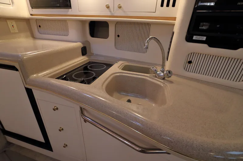Slide: The Image of 2000 Sea Ray 340 Sundancer yacht kitchen with sink and stovetop. - 20