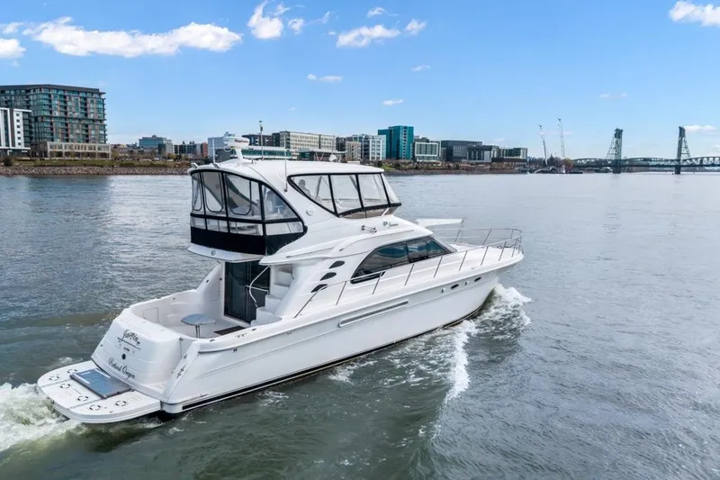 Slide: The Image of 1999 Sea Ray 560 Sedan Bridge yacht cruising near urban waterfront. - 15